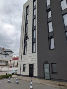 alpinista myje okna w hotelu na linie